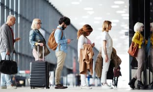 people waiting in line at an airport checkpoint 